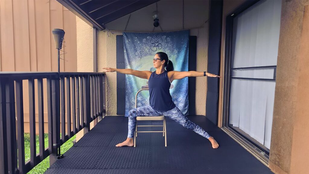 Soraya Riera in a variation of the "Virabhadrasana II" Yoga Asana, during "Chair Yoga" practice