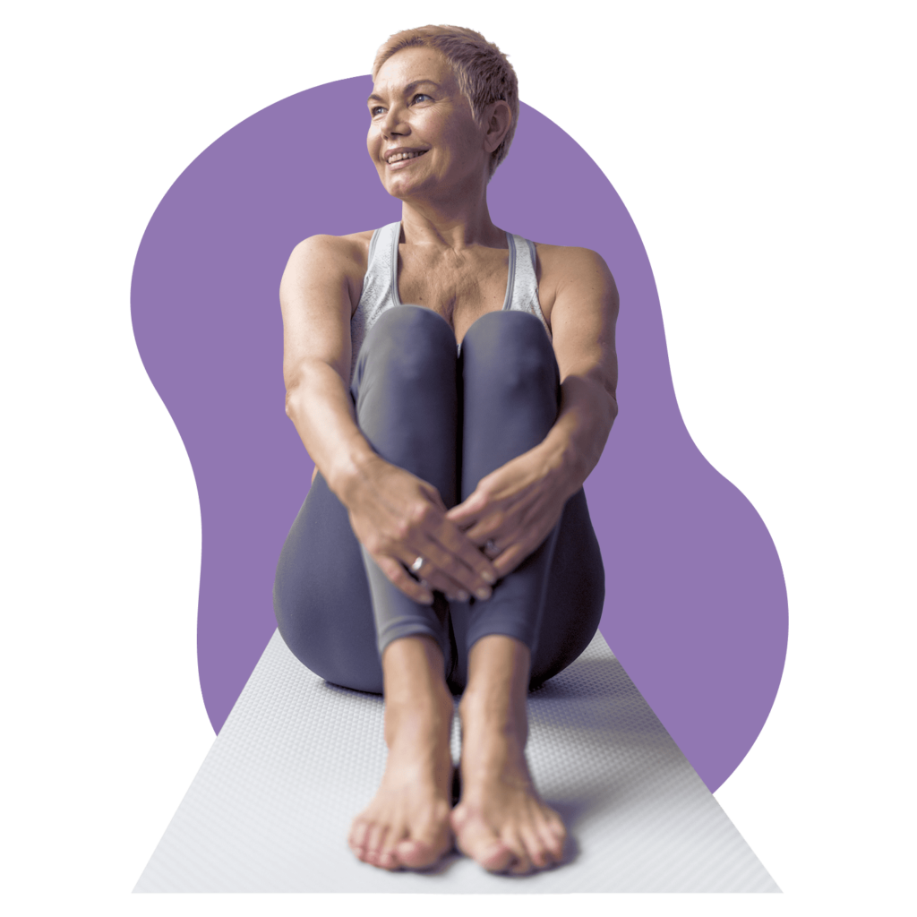 Woman sitting in a relaxed position on a yoga mat